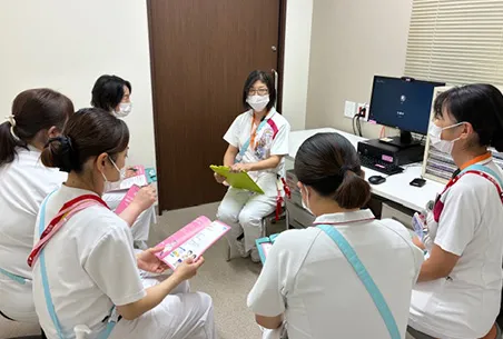 画像:救急看護の看護師が救急車の前に立っている