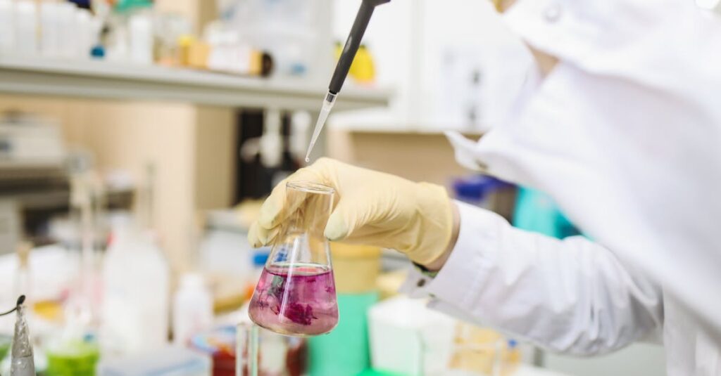 Scientist using a pipette for chemical analysis in a modern laboratory.